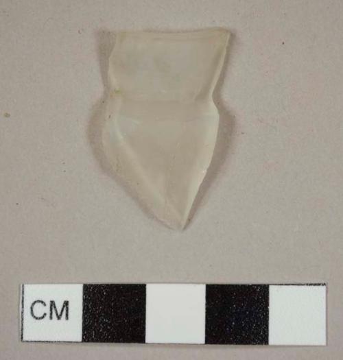 Colorless bottle glass fragment with molded faceted exterior and narrow mouth, evidence of wear on the interior of the mouth suggests it once had a stopper