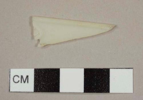 Cream-colored plastic cutlery fragment