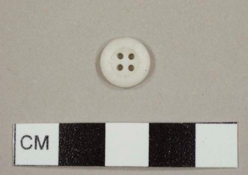 Four-holed white shirt button, either plastic or ceramic