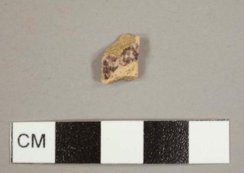 Tin-glazed earthenware sherd with pinkish paste and mottled manganese glaze on exterior and plain white interior