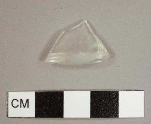 Colorless curved glass fragment, possibly from a bottle base