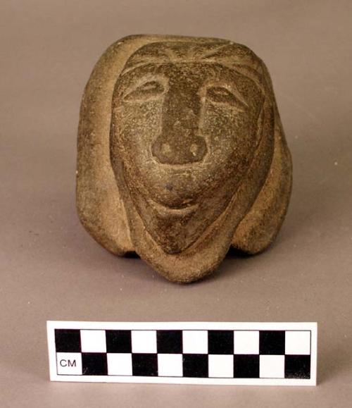 Stone face.  Dimensions: 10.5 x 11.5 cm. Thickness: 7 cm.