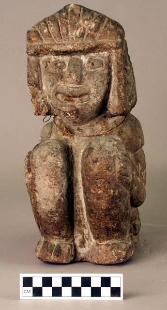 Carved stone effigy, human, seated, headdress and features in relief