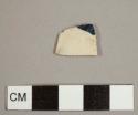 Refined, white bodied earthenware sherd with chip of dark blue glaze