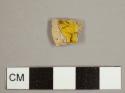 Staffordshire-type slipware fragment with yellow and brown marbled glaze on one side and plain yellow on the reverse
