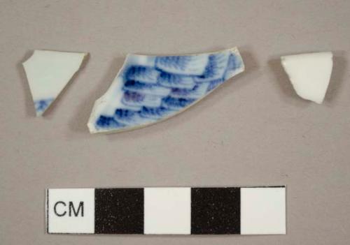 Porcelain sherds, two with blue decoration and one plain rim sherd from a plate