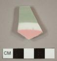 Porcelain plate rim fragment with grey and pink stripes on interior and molded ribs on the exterior/underside