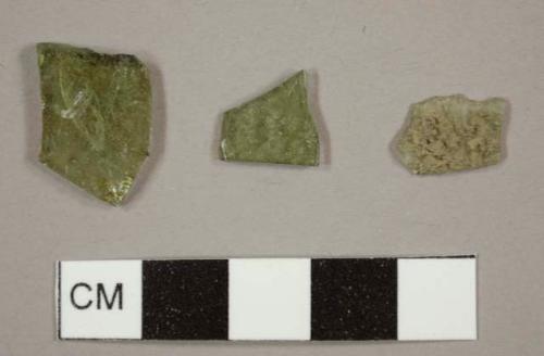 Olive green bottle glass fragments and one burned colorless glass fragment