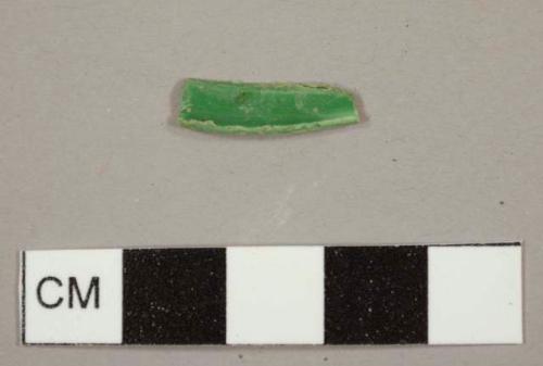 Curved green plastic fragment