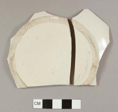 White salt-glazed stoneware bowl base sherds that mend together