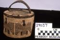 Oval weave basket, coiled. Design: bird motif. Cover with handle.
