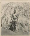 Woman standing in front of a hut