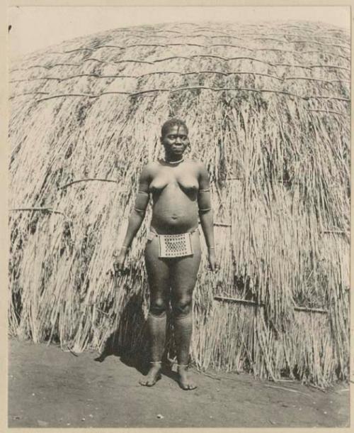 Woman standing in front of a hut