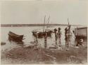 Women carrying pots to shore