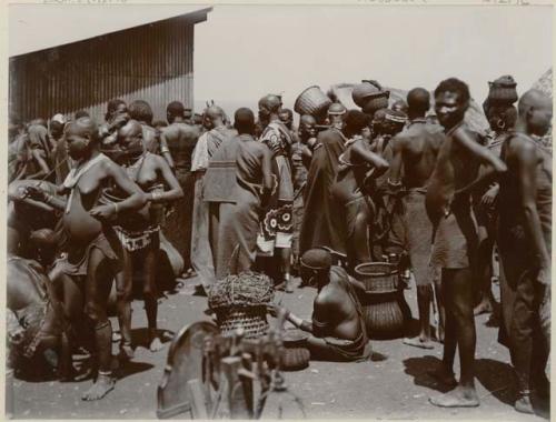 Woman sitting with baskets, group standing