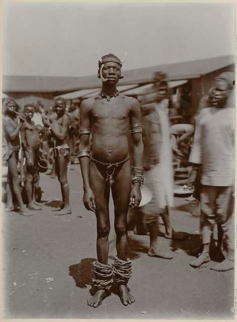 Man standing, with people and building in background