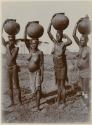 Four women carrying pots on their heads