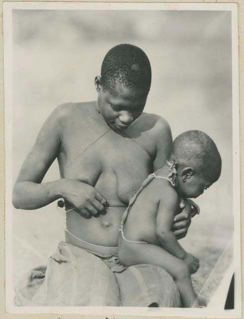 Woman holding baby with charms