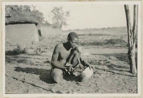 Man making a wooden bowl or "mekeke"