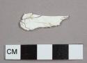 Opaque white plastic handle fragment, possibly from a spoon or fork