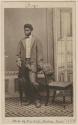 Studio portrait of a man standing next to a chair