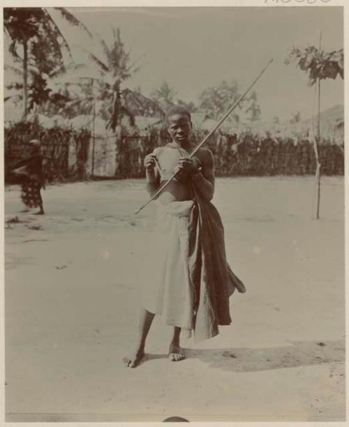 Man standing, with wall or fence in background