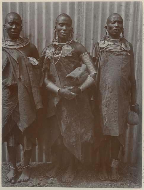 Three women standing in front of a building