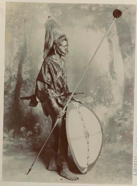 Studio portrait of a man standing and holding a spear and shield