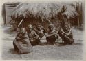 Group of men in front of a hut