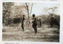 Two people standing outside next to a tree