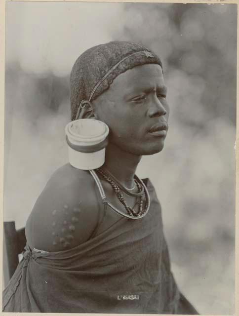 Man with large ear plug and scarification