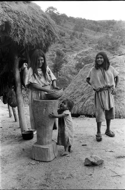 Ika woman and child with corn and mortar
