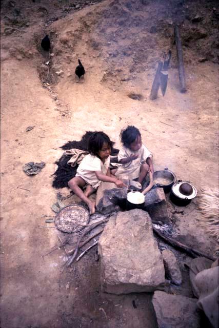 Two Ika children near fire
