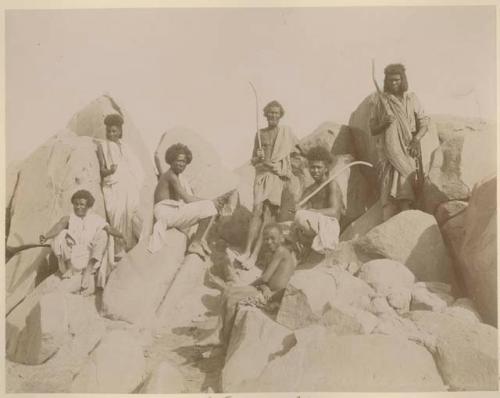 Group of men and boys sitting on rocks