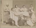 Group of men and women with musical instruments and cups, one smoking