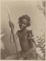 Boy sitting and holding a spear