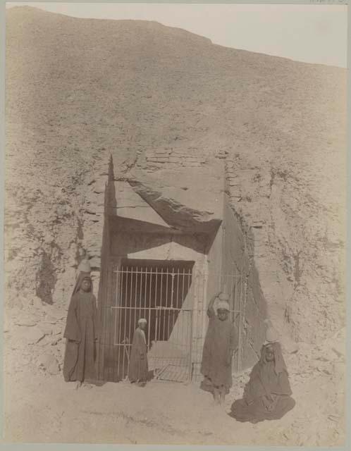 Group of people in front of gated doorway on tomb of Ramses IV