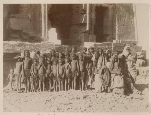 Group of women and children in front of ancient building