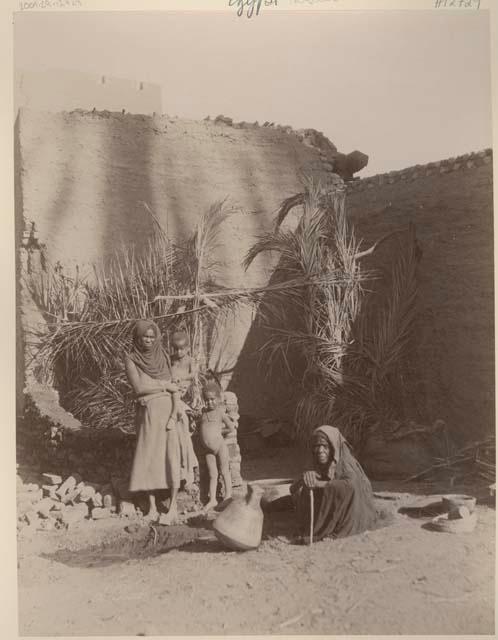 Two women and two children in a courtyard