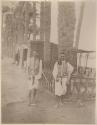 Two soldiers in front of a small building and trees