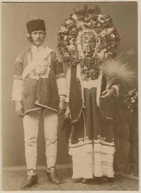 Studio portrait of a man, and a woman wearing a headdress