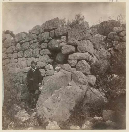 Man standing next to stone wall