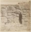 Man standing next to stone wall