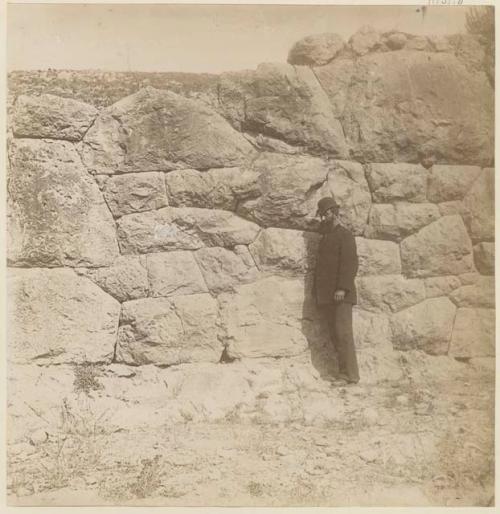 Man standing next to stone wall