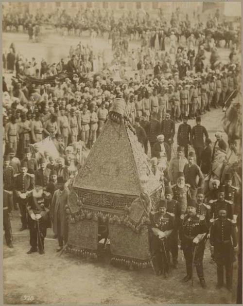 Large group of men in uniform with ornate tent