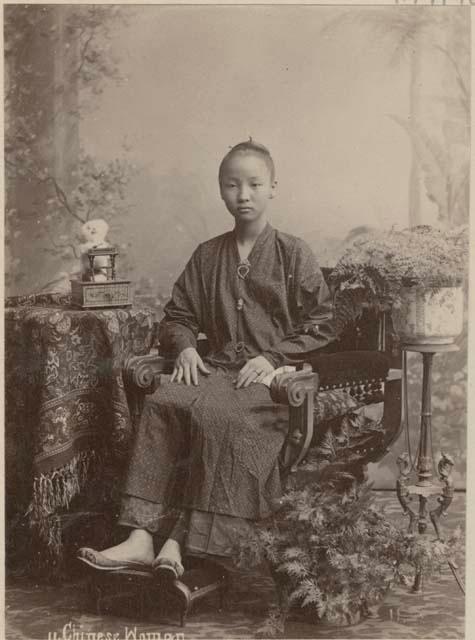 Portrait of sitting Chinese woman next to plants