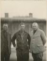 Two German men and an American man outside building