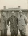 Two German men and an American man outside building