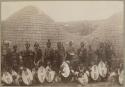 Zulu warriors in front of a hut