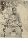 Man sitting and holding a brass musical instrument